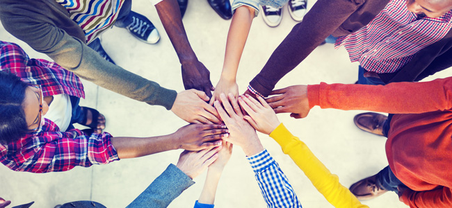 people reaching their hands together in a circle